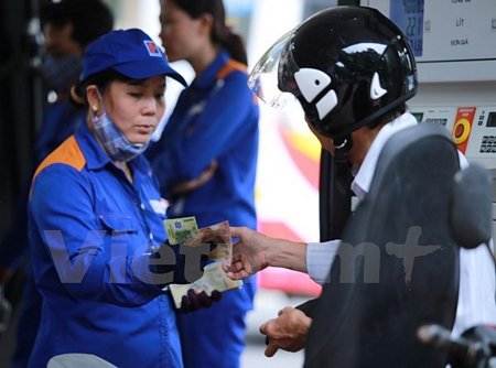 Nhân viên Petrolimex đang bán xăng cho khách hàng. (Ảnh: Đức Duy/Vietnam+)