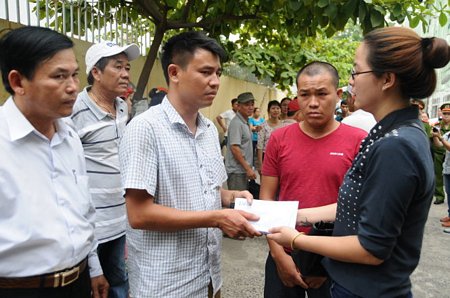 Đại diện công ty IVC trao số tiền 60 triệu đồng cho gia đình anh anh Trịnh Tiến Dương có 2 con bị mất trong vụ lật tàu du lịch trên sông Hàn. Ảnh: Đ.NAM