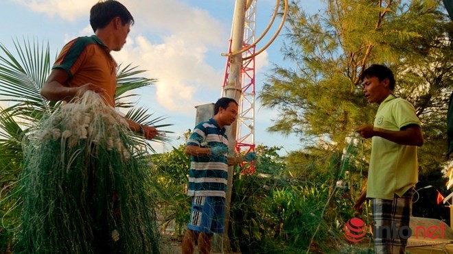 Những người đàn ông thu lưới sau một ngày đánh cá. Ngoài việc này, họ còn là những dân quân tự vệ sẵn sàng bảo vệ đảo khi cần thiết.