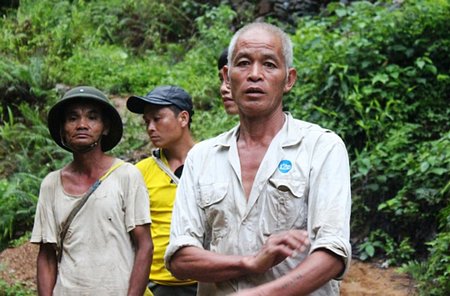 Ông Bùi Văn Quyên (bìa phải) và người thân đang chờ các cơ quan chức năng đưa thi thể anh Huyền lên để về lo hậu sự