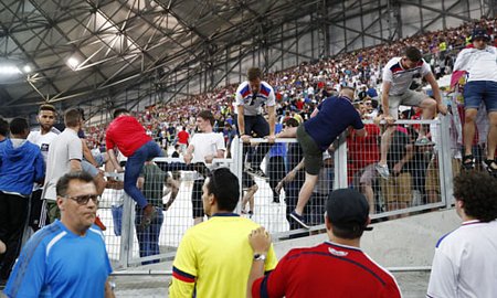 CĐV Anh trèo qua hàng rào trên khán đài để chạy khỏi cuộc ẩu đả trên khán đài. Ảnh:Reuters.