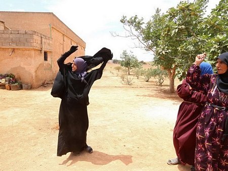 Phụ nữ ở một ngôi làng nằm ở ngoại ô thành phố Manbij hân hoan cởi bỏ niqab. (Nguồn: Reuters)