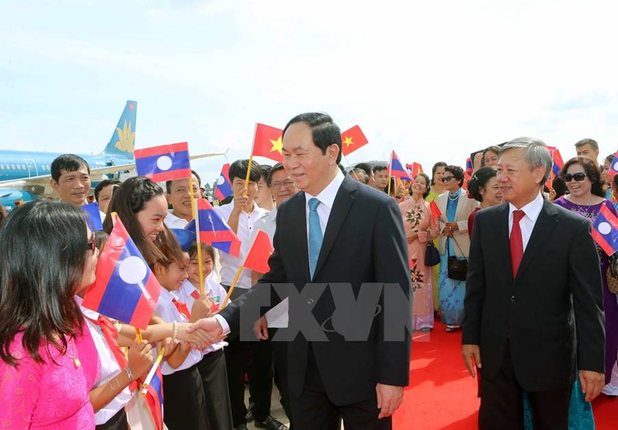 Đại diện Nhà nước Lào cùng cán bộ nhân viên Đại sứ quán Việt Nam và đông đảo kiều bào đón Chủ tịch nước Trần Đại Quang và phu nhân tại sân bay quốc tế Wattay. (Ảnh: Nhan Sáng/TTXVN)