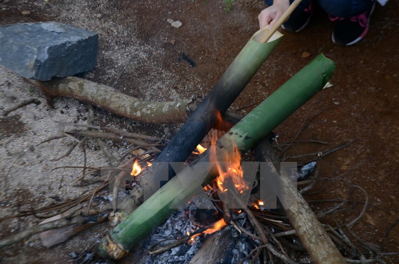 Sau đó, người nấu sẽ dùng một ống tre thụt tới thụt lui cho đến khi canh trong ống nhuyễn nhừ. (Ảnh: Hưng Thịnh/TTXVN)