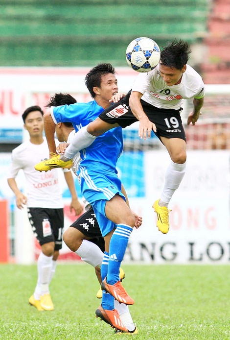 Pha tranh bóng giữa đội Long An (áo trắng) trong trận thắng Vĩnh Long 4-2.