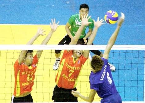 Pha tranh bóng giữa đội Visakha (Campuchia, áo xanh) trong trận khai mạc gặp đội XSKT Vĩnh Long tại Giải Bóng chuyền quốc tế Arirang 2016. Ảnh: DƯƠNG THU