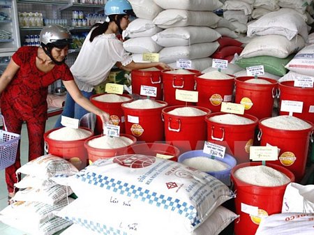 Người tiêu dùng mua gạo trên thị trường. (Ảnh: Đình Huệ/TTXVN)