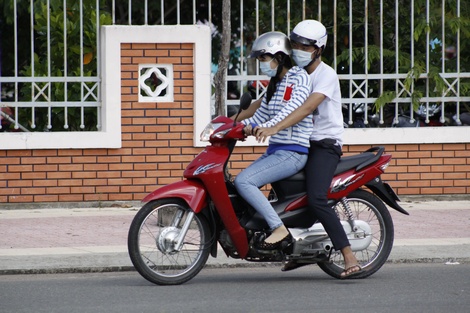 Người ngồi phía sau vòng tay qua người ngồi trước để điều khiển xe (trừ trường hợp chở trẻ em ngồi phía trước), bị phạt tiền từ 100.000- 200.000đ.Ảnh: ĐÔNG BÌNH