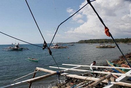 Một ngư dân sửa chữa thuyền tại bãi cạn Scarborough. (Nguồn: Reuters)