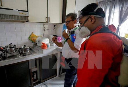 Nhân viên Công ty NEA hướng dẫn người dân diệt muỗi trong nhà ở quận Bedok North ngày 1/9. (Nguồn: EPA/ TTXVN)