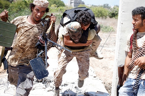 Cõng thương binh về vị trí ẩn nấp trong trận Sirte, Libya.