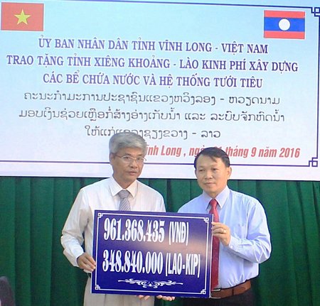  Nguyễn Minh Tho- Giám đốc Sở Nông nghiệp và PTNT (bìa trái) trao biểu trưng số tiền trên cho đại diện tỉnh Xiêng Khoảng 
