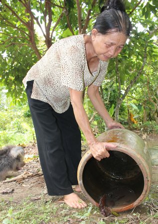 Người dân đổ cặn lu nước, hạn chế nơi trú ngụ sinh sôi của lăng quăng, muỗi.