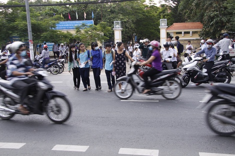 Nhiều người học sinh lớp 10, chưa quen nên sang đường phải dựa vào người lớn dẫn sang đường.