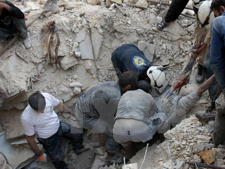 Tình nguyện viên Syria chuyển thi thể một nạn nhân sau một vụ không kích tại Aleppo ngày 4/10. (Nguồn: AFP/TTXVN)