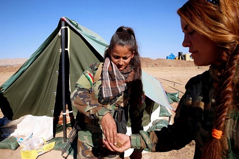 Hai nữ chiến binh chia sẻ cho nhau những viên đạn khi tham gia trận đánh ở Bashiqa, gần Mosul, Iraq.