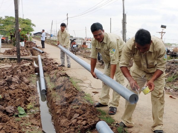 Lắp đặt ống cấp nước cho người dân vùng hạn mặn. (Ảnh: Hoài Thu/TTXVN)