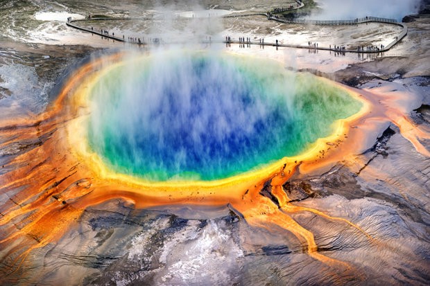 Hồ nước nóng Grand Prismatic Spring được phát hiện vào năm 1871, đây là nơi có nguồn suối nước nóng lớn nhất tại Mỹ và lớn thứ ba thế giới. Vào mùa xuân, cảnh sắc của hồ như một bức tranh vô cùng sống động, nhiều màu sắc như đỏ, cam, vàng, xanh lá cây hay xanh da trời. Theo các nhà khoa học, hiện tượng thay đổi màu nước độc đáo như vậy là do một số loại vi khuẩn sắc tố phát triển trên các thảm vi sinh vật xung quanh hồ tạo nên.