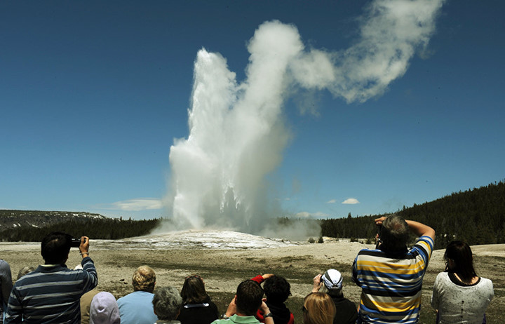 Du khách chiêm ngưỡng mạch nước phun Old Faithful trong công viên quốc gia Yellowstone, Wyoming, Mỹ. Trung bình cứ 90 phút, mạch nước này lại phun một lần. Ảnh: AFP