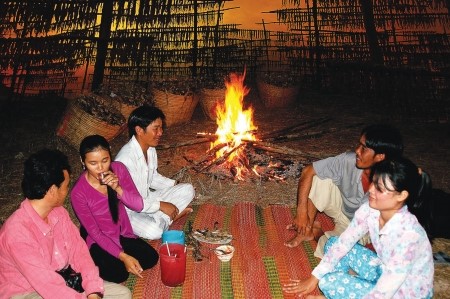 Sau một ngày lao động vất vả, người lao động nhâm nhi ly rượu với khô khoai bên bếp lửa hồng.