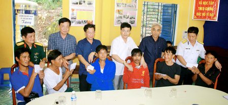 Bộ Tư lệnh Vùng E Hải quân và các tỉnh, thành trao tiền, động viên 9 ngư dân bị nạn. Ảnh: DƯƠNG THU