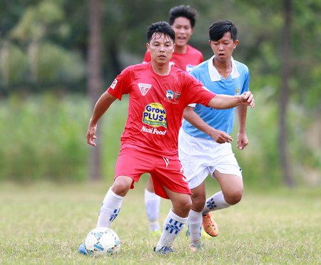 Pha tranh bóng trong trận Trung Thành Đông (Vũng Liêm, áo đỏ) thắng Mỹ Hòa (TX Bình Minh) 8-1.