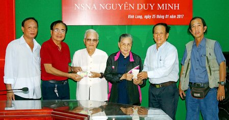 Nhà nhiếp ảnh lão thành Nguyễn Duy Minh (thứ ba bên trái sang) nhận quà tặng của Hội NSNA Việt Nam và quà tặng của Hội NSNA Việt Nam tỉnh Vĩnh Long.    