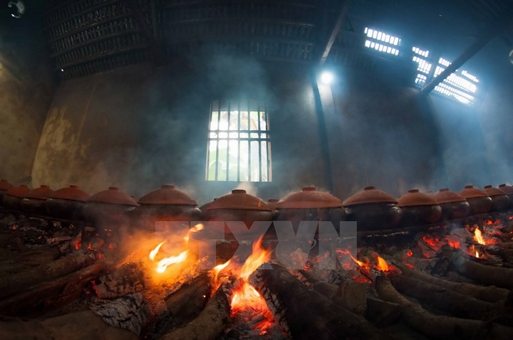 Cá được kho theo phương thức cổ truyền: kho bằng niêu đất trên bếp củi suốt 10 tiếng đồng hồ để cá mềm và thấm, có thể ăn được cả xương. (Ảnh: Trọng Đạt/TTXVN)