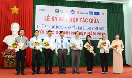 Trường CĐ Kinh tế- Tài chính Vĩnh Long tặng hoa cho đại diện đơn vị, doanh nghiệp tham gia ký kết.