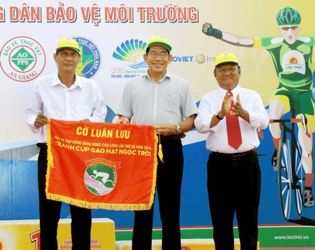 Ông Nguyễn Thanh An- Phó GĐ Sở Văn hóa, Thể thao và Du lịch tỉnh (bên trái), ông Nguyễn Văn Thanh- Chủ tịch LĐ.XDMTTT tỉnh Vĩnh Long (giữa) nhận cờ luân lưu đăng cai mùa giải 2017.