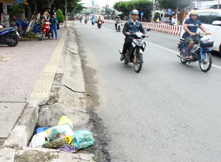 Rác sinh hoạt do người dân để chặn bít cửa hố ga thoát nước. Khi có mưa, nước biết chảy đường nào?