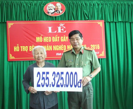 Đại tá Nguyễn Văn Hiểu- Tỉnh ủy viên, Phó Giám đốc Công an tỉnh trao số tiền mổ heo đất cho đại diện Hội Người khuyết tật, bảo trợ trẻ mồ côi và bệnh nhân nghèo tỉnh.