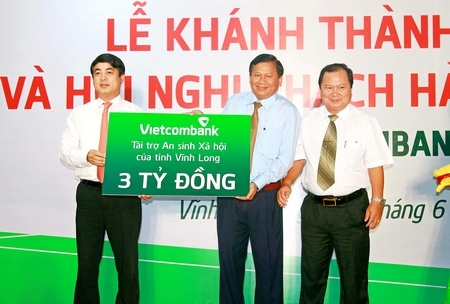 Ông Nghiêm Xuân Thành- Chủ tịch HĐQT Vietcombank (trái) trao số tiền 3 tỷ đồng cho quỹ an sinh xã hội Vĩnh Long đến Chủ tịch UBMTTQ tỉnh- Lê Quang Đạo (giữa) trước sự chứng kiến của ông Nguyễn Văn Quang- Chủ tịch UBND tỉnh.