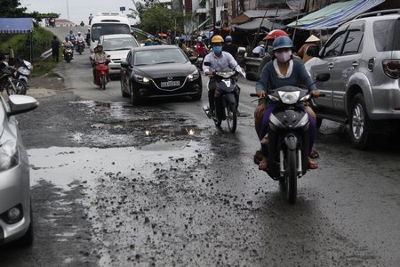 Hai bên mố cầu Ngã Tư thường xuyên ứ đọng nước vào mùa mưa do nhiều “ổ gà”, “ổ voi” và đến mùa nước nổi thì ngập sâu đến 20- 30cm.