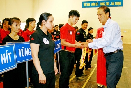Ông Nguyễn Thanh An- Phó Giám đốc Sở Văn hoá, Thể thao và Du lịch tỉnh trao cờ lưu niệm cho các đoàn VĐV tham dự giải tại lễ khai mạc.