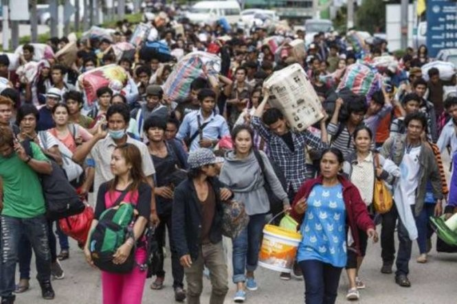 Lao động nhập cư Campuchia lỉnh kỉnh hành lý đi bộ qua cửa khẩu biên giới Aranyaprathet, tỉnh Sa Kaew hồi năm 2014 - Ảnh: Reuters