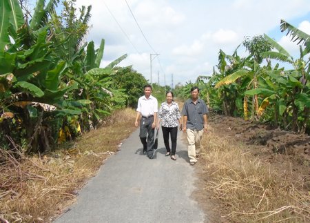 Ông Đỗ Mạnh Cường (bìa phải) đi trên con đường khang trang, thuận lợi giao thương do ông huy động sức dân mà có.