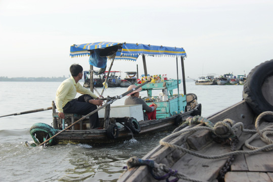 Một cặp vợ chồng với con thuyền gắn máy, bán cà phê và nước ngọt