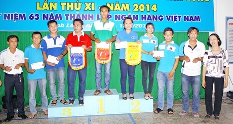 VĐV của đơn vị Vietcombank Vĩnh Long (giữa) nhận giải thưởng hạng nhất tại Hội thao ngành Ngân hàng tỉnh Vĩnh Long.