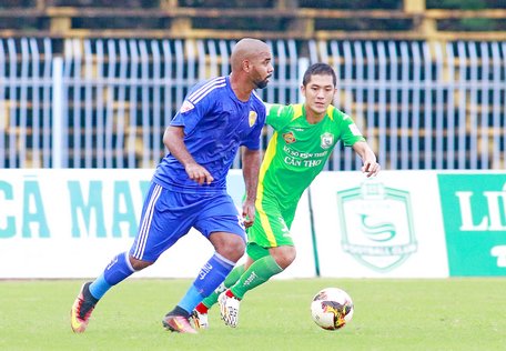 Trung Anh (32, XSKT Cần Thơ- áo xanh lá) tranh bóng trước Dos Reis (89, Quảng Nam FC).