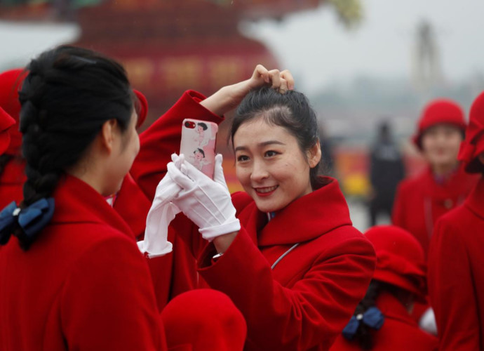 Dù nhiệm vụ không hề nhẹ nhàng nhưng các cô gái trẻ này vẫn không quên làm đẹp… Ảnh: Reuters.