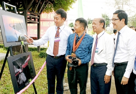 Các vị đại biểu bên bức ảnh đạt huy chương vàng của Nghệ sĩ nhiếp ảnh Nguyễn Vinh Hiển. Ảnh: DƯƠNG THU