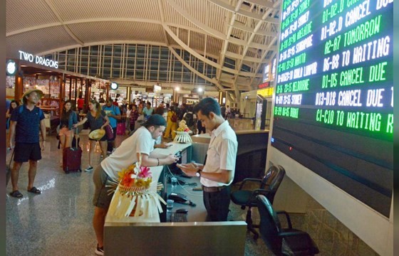 Du khách xem thông tin chuyến bay tại sân bay Ngurah Rai, Bali, Indonesia ngày 25/11/2017. ảnh: REUTERS