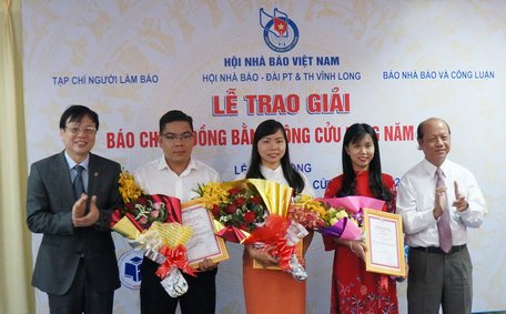 Nhà báo Hồ Quang Lợi- Phó Chủ tịch Thường trực Hội Nhà báo Việt Nam (bìa trái)- và ông Trương Văn Sáu- Phó Bí thư Thường trực Tỉnh ủy, Chủ tịch HĐND tỉnh Vĩnh Long (bìa phải)- trao hoa và chứng nhận cho nhóm tác giả đoạt giải nhất.