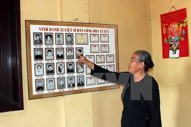 Bà Phạm Thị Ôi chia sẻ thông tin những liệt sỹ, là đồng đội trong đoàn dân công hỏa tuyến năm xưa. (Ảnh: Tiến Lực/TTXVN)