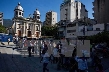 Người dân Venezuela xếp hàng chờ đổi tiền bên ngoài ngân hàng trung ương ở Caracas. (Nguồn: AFP/TTXVN)