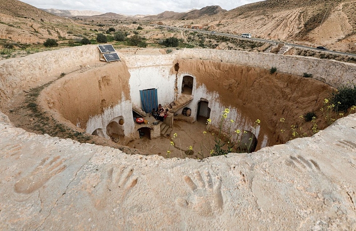 Chị Saliha Mohamedi, 36 tuổi, ngồi cùng với các con bên ngoài troglodyte ở Matmata, Tunisia. 