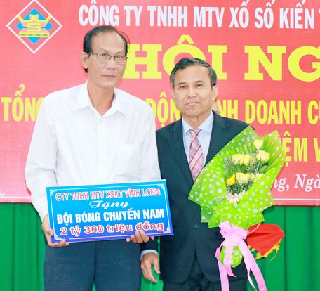 Ông Thiệu Ngọc Tâm- Giám đốc Công ty TNHH 1TV XSKT Vĩnh Long (phải) trao bảng tượng trưng tiền tài trợ đội bóng chuyền nam của tỉnh 2018 cho ông Nguyễn Thanh An- Phó Giám đốc Sở Văn hóa, Thể thao và Du lịch.