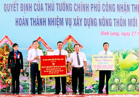 Ông Nguyễn Văn Quang- Phó Bí thư Tỉnh ủy, Chủ tịch UBND tỉnh, Trưởng Ban chỉ đạo thực hiện công tác giảm nghèo bền vững, xây dựng nông thôn mới và đô thị văn minh tỉnh (thứ 2 bên phải) trao tặng cờ thi đua và biểu trưng khen thưởng công trình 10 tỷ đồng cho TX Bình Minh.