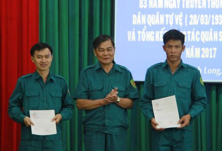  Ông Hồ Duy Linh (đứng giữa)- Giám đốc Kho bạc Nhà nước Vĩnh Long, trao quyết định kết nạp chiến sĩ tự vệ cơ quan.